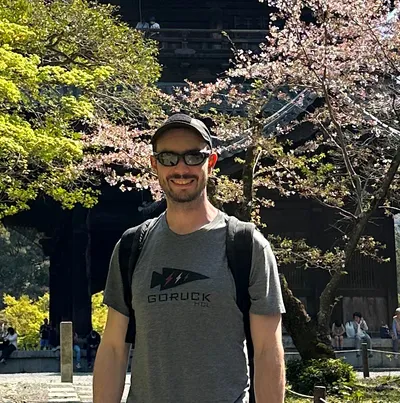 Owner posing in front of trees